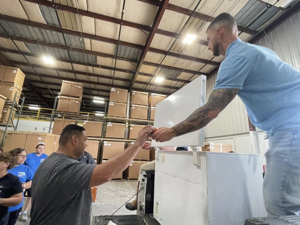 Nashville employee receives a giveaway item during workplace loyalty rewards handout in warehouse